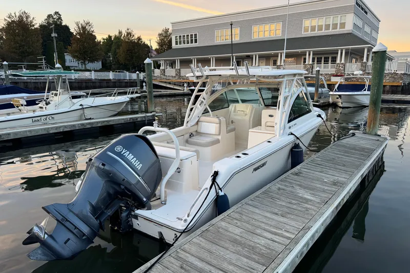 Slide: The Image of 2012 Pursuit DC 265 Dual Console boat docked with Yamaha outboard engine. - 2