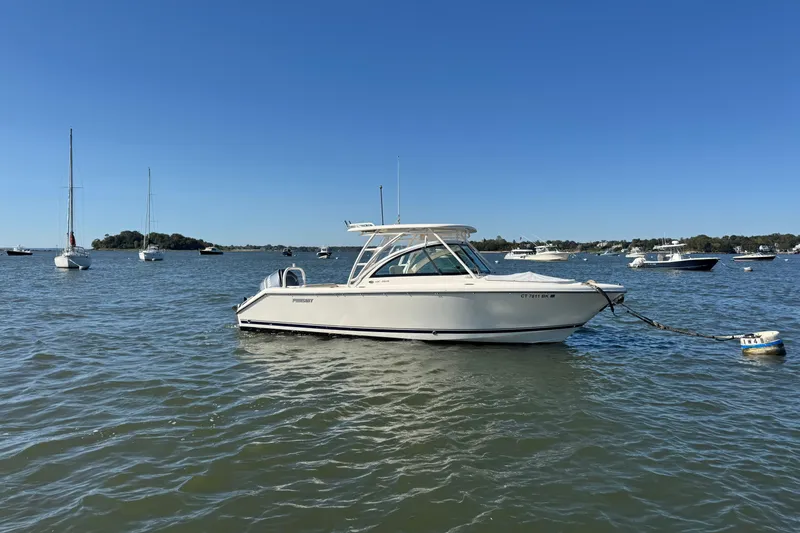 Slide: The Image of 2012 Pursuit DC 265 Dual Console boat anchored in a scenic bay. - 3