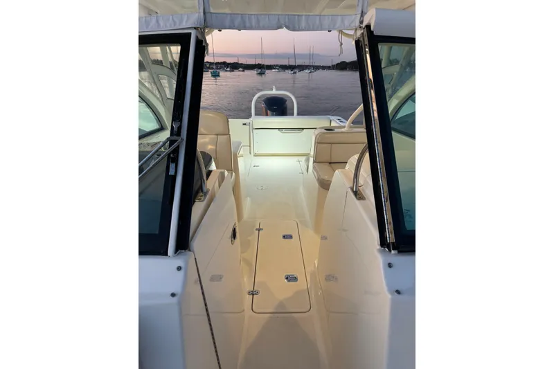 Slide: The Image of 2012 Pursuit DC 265 Dual Console boat interior with sunset view over marina. - 6