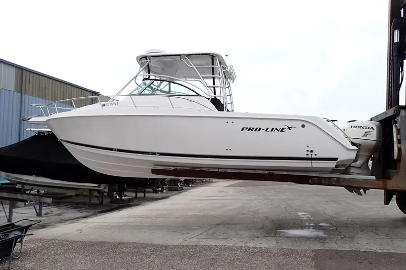 The Image of 2002 Pro-Line 33 WA boat with Honda outboard motor on a lift. - 1