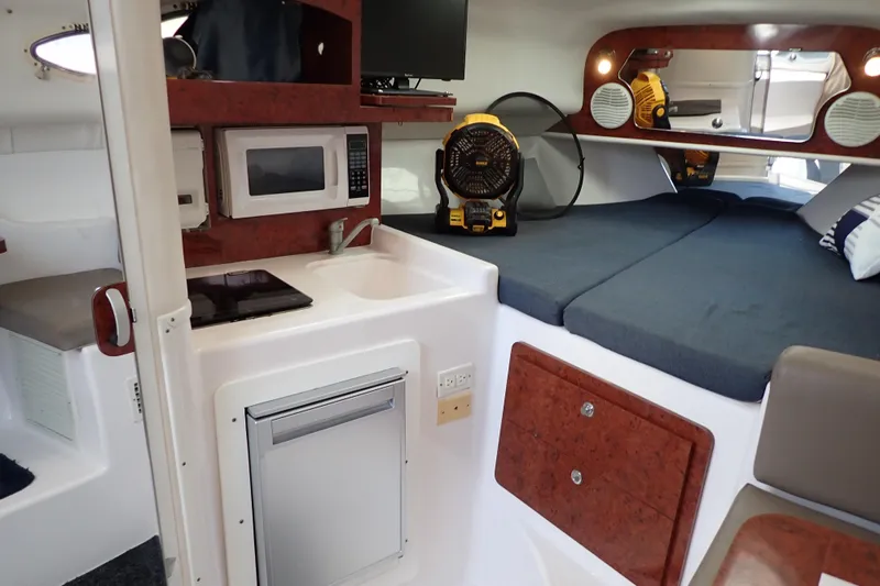 Slide: The Image of 2002 Pro-Line 33 WA boat interior with kitchenette, bed, and modern amenities. - 20