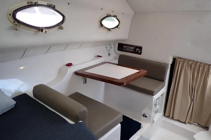 Slide: The Image of 2002 Pro-Line 33 WA cabin interior with seating, table, and portholes. - 21