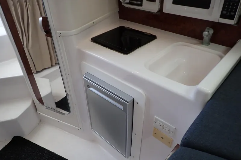 Slide: The Image of Compact kitchen area in a 2002 Pro-Line 33 WA boat with sink and stove. - 23