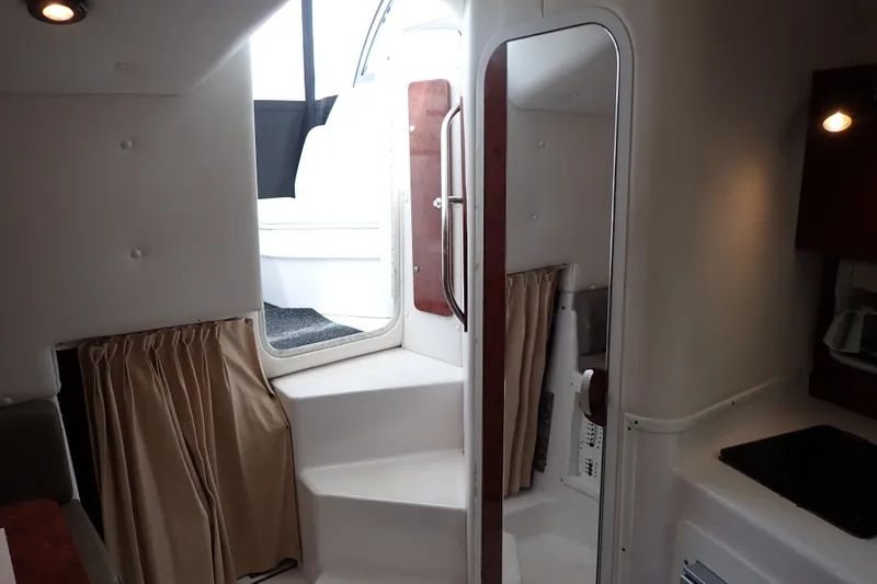 Slide: The Image of Interior of 2002 Pro-Line 33 WA boat, featuring stairs, mirror, and kitchenette area. - 24