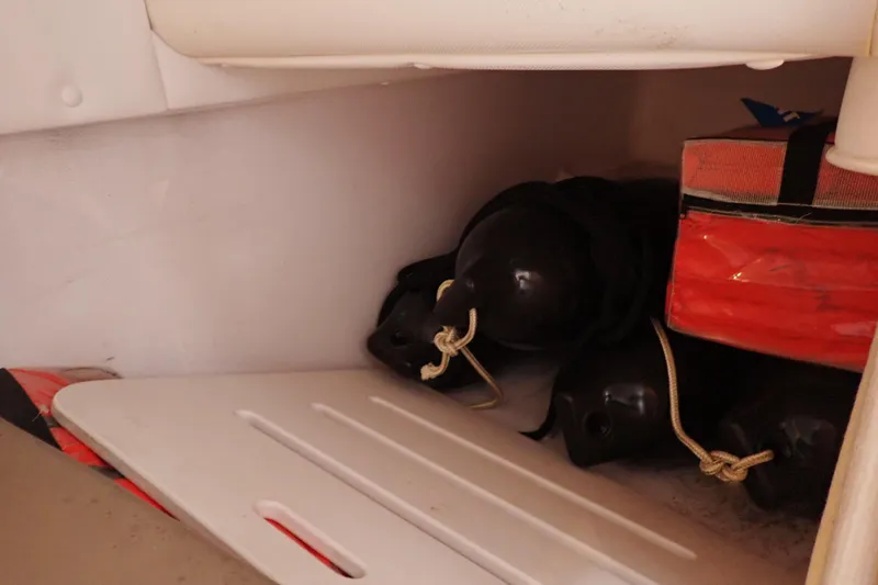 Slide: The Image of Storage compartment in 2002 Pro-Line 33 WA boat with fenders and safety equipment. - 29
