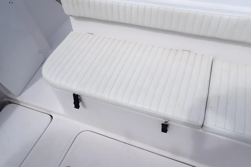 Slide: The Image of White cushioned seating on 2002 Pro-Line 33 WA boat, featuring striped upholstery. - 36