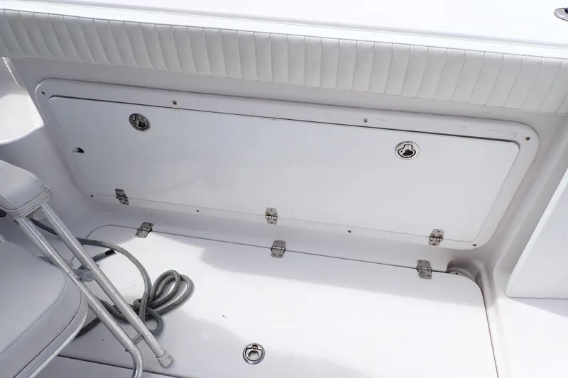 Slide: The Image of 2002 Pro-Line 33 WA boat deck with storage compartment and coiled rope. - 38