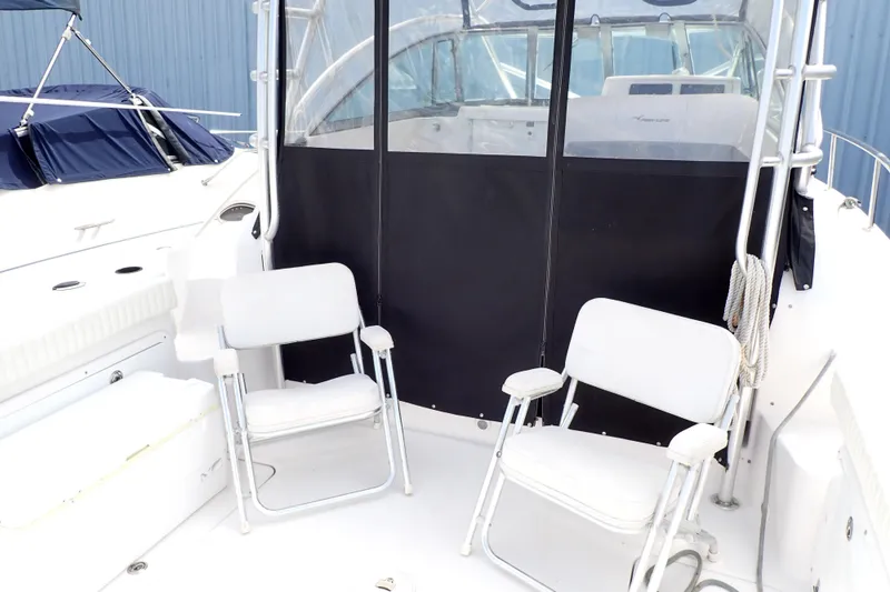 Slide: The Image of 2002 Pro-Line 33 WA boat interior with two white folding chairs. - 4