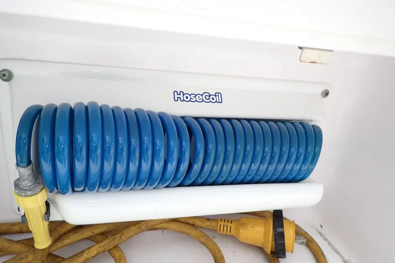 Slide: The Image of Blue HoseCoil on 2002 Pro-Line 33 WA boat, neatly coiled with yellow plug. - 41