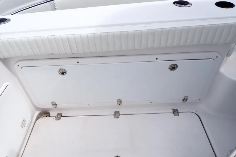 Slide: The Image of 2002 Pro-Line 33 WA boat interior with white cushioned seating and storage compartment. - 43