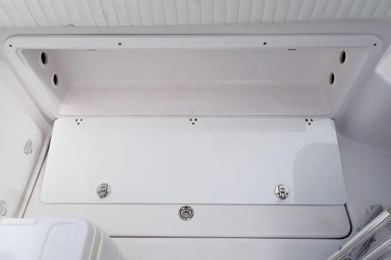 Slide: The Image of 2002 Pro-Line 33 WA boat storage compartment with secure latches and clean white interior. - 44