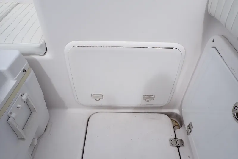 Slide: The Image of 2002 Pro-Line 33 WA boat interior storage compartment with white seating and hatch. - 45