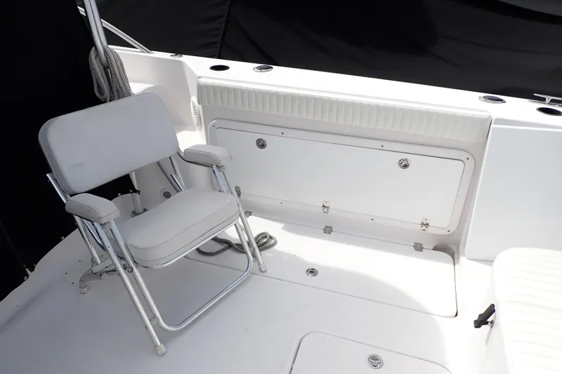 Slide: The Image of 2002 Pro-Line 33 WA boat interior with folding chair and storage compartment. - 6