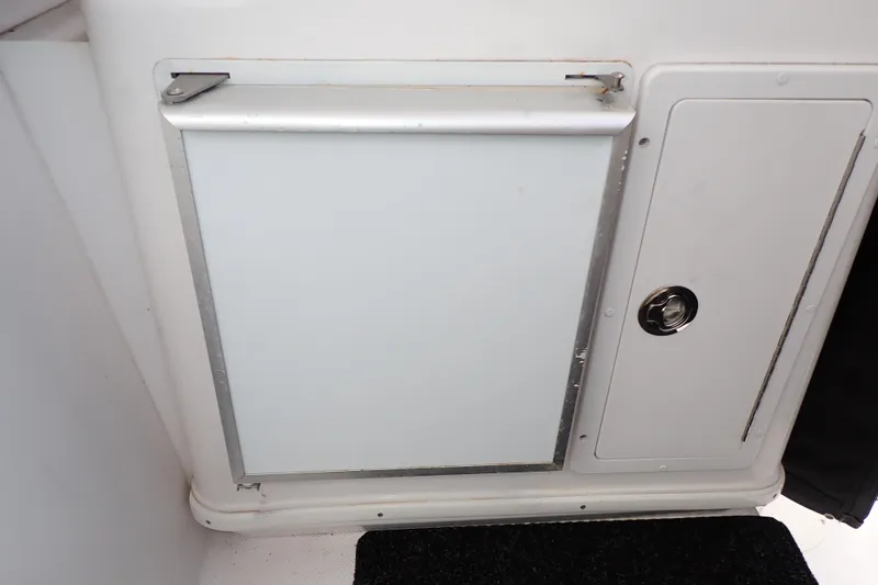 Slide: The Image of 2002 Pro-Line 33 WA boat interior storage compartment with white panel and latch. - 60