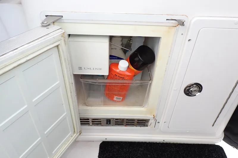 Slide: The Image of Open storage compartment on 2002 Pro-Line 33 WA boat with cleaning supplies inside. - 61