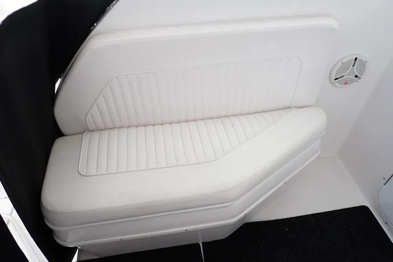 Slide: The Image of 2002 Pro-Line 33 WA boat interior with white cushioned seating and speaker. - 63