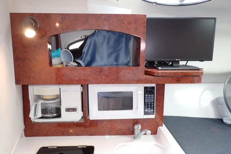 Slide: The Image of 2002 Pro-Line 33 WA boat interior with microwave, coffee maker, and TV setup. - 68