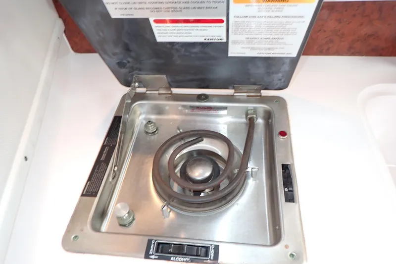 Slide: The Image of 2002 Pro-Line 33 WA boat stove with coiled burner and safety instructions. - 70