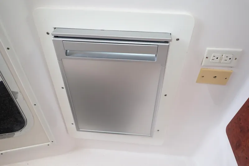 Slide: The Image of Built-in refrigerator and electrical outlets on a 2002 Pro-Line 33 WA boat interior. - 74