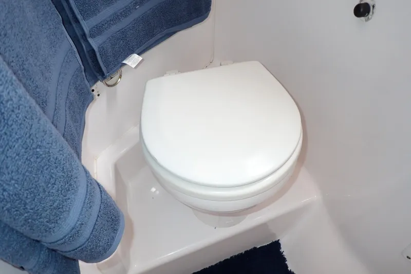 Slide: The Image of 2002 Pro-Line 33 WA boat bathroom with white toilet and blue towels. - 86
