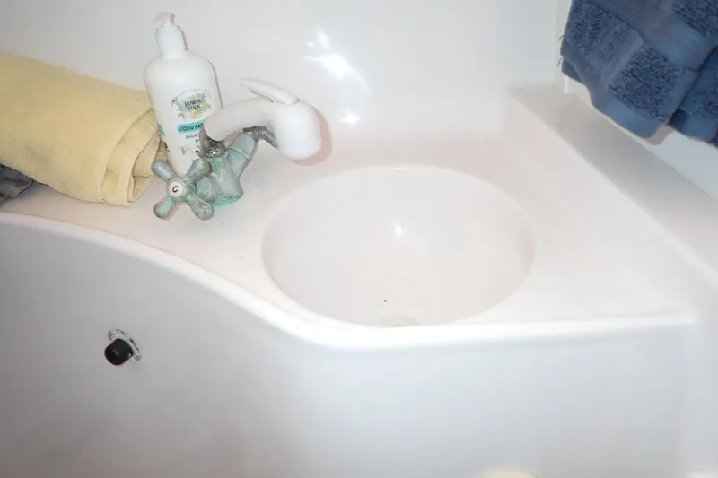 Slide: The Image of Small sink area in 2002 Pro-Line 33 WA boat with faucet, soap, and towels. - 88