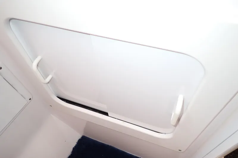 Slide: The Image of 2002 Pro-Line 33 WA boat interior hatch with white handles and sleek design. - 89