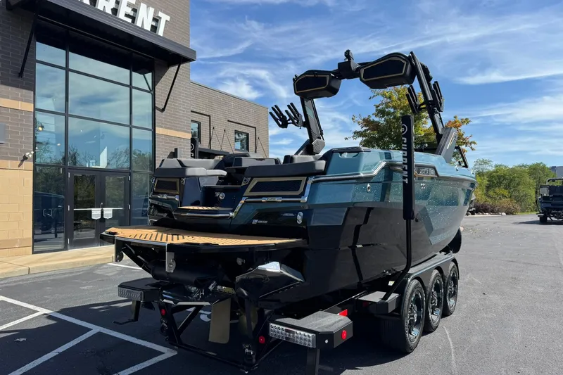 Slide: The Image of 2025 MasterCraft XStar 25 boat on trailer outside a modern building. - 4
