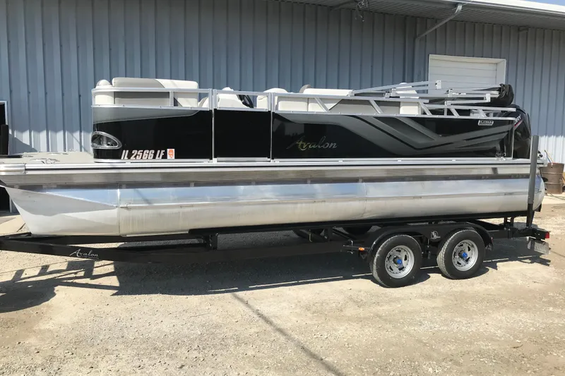 Slide: The Image of 2024 Avalon VENTURE FISH-N-CRUISE pontoon boat on trailer, parked outdoors. - 10