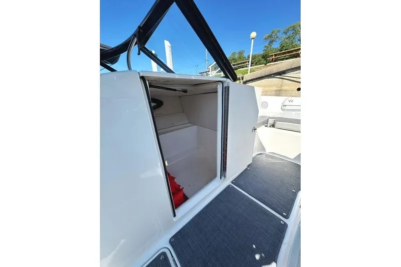 Slide: The Image of 2022 Bayliner VR6 Bowrider OB open storage compartment at marina dock. - 20