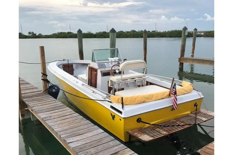 The Image of Yellow 1978 Formula boat docked on calm water with wooden pier. - 0