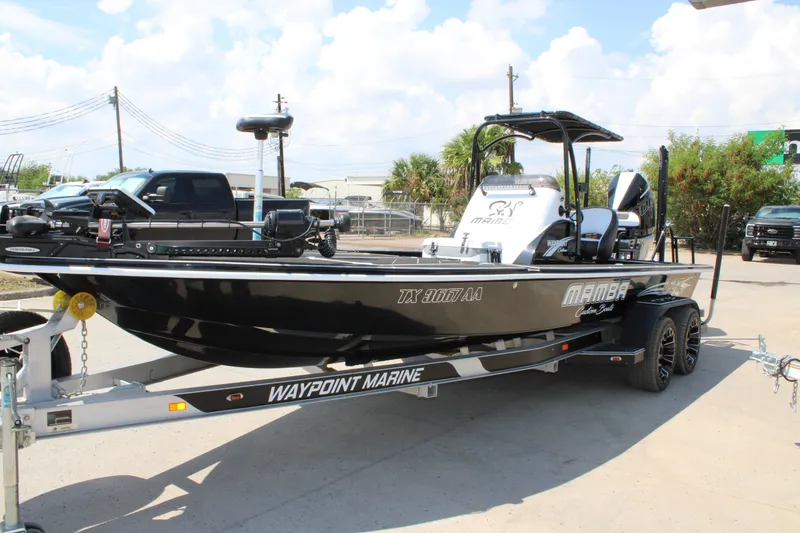 Slide: The Image of 2026 Mamba 227VX boat on trailer, black and white design, parked outdoors. - 13