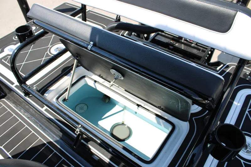 Slide: The Image of Open storage compartment on 2026 Mamba 227VX boat with black seating and cup holders. - 19