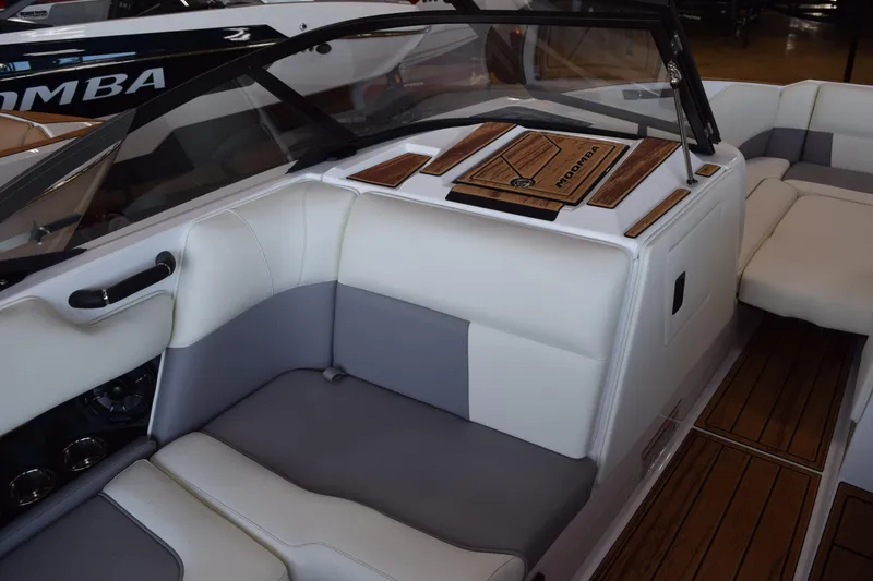Slide: The Image of 2025 Moomba Craz boat interior with white and gray seating, wood accents, and sleek design. - 18