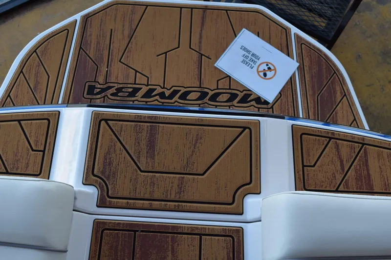 Slide: The Image of 2025 Moomba Craz boat deck with wood finish and "Please Take Off Your Shoes" sign. - 22