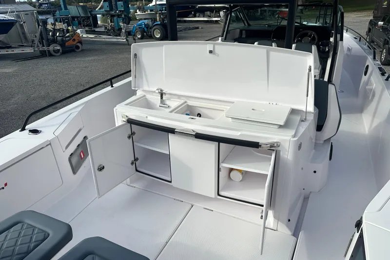 Slide: The Image of 2022 Axopar 37 Sun Top boat on a calm river, showcasing sleek design and spacious deck. - 11