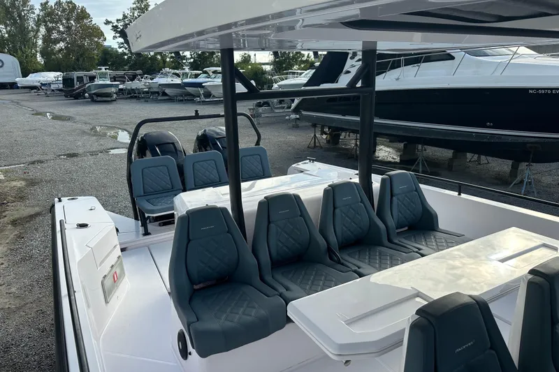 Slide: The Image of 2022 Axopar 37 Sun Top boat with outdoor sink and storage, docked by a marina. - 12