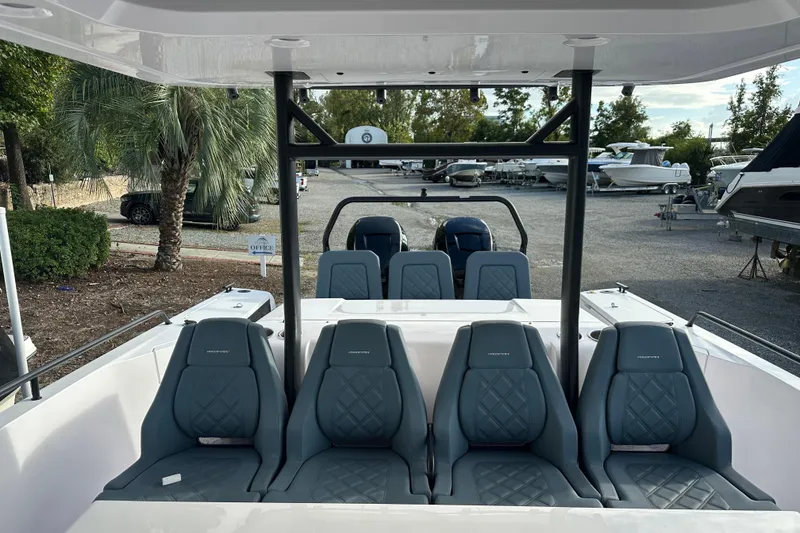 Slide: The Image of 2022 Axopar 37 Sun Top boat interior with seating and table on a sunny day. - 17