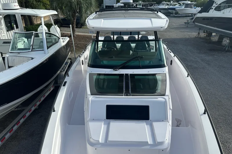 Slide: The Image of 2022 Axopar 37 Sun Top boat interior with seating and table on a sunny day. - 18