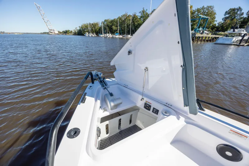 Slide: The Image of 2022 Axopar 37 Sun Top boat with open storage compartment on a calm river. - 24