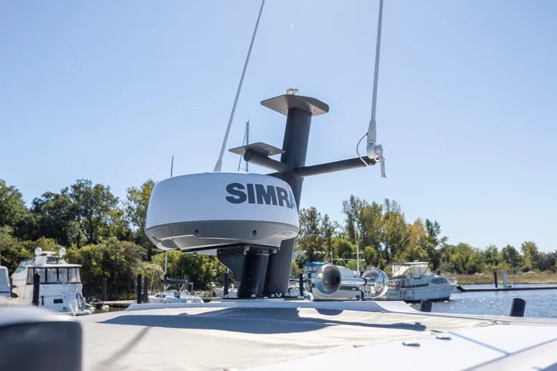 Slide: The Image of Radar equipment on 2022 Axopar 37 Sun Top boat, docked near trees and other boats. - 26