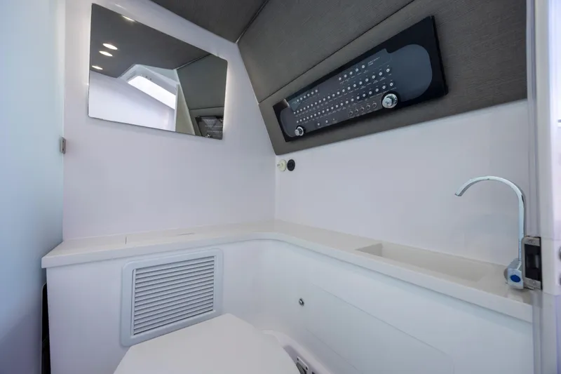 Slide: The Image of Interior of 2022 Axopar 37 Sun Top boat bathroom with modern fixtures and mirror. - 29