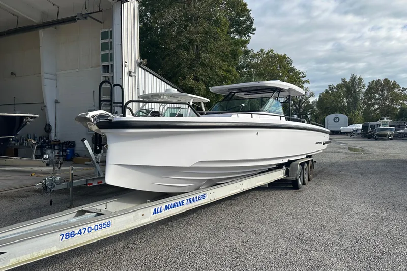 Slide: The Image of 2022 Axopar 37 Sun Top boat cruising on a river near industrial dock. - 4