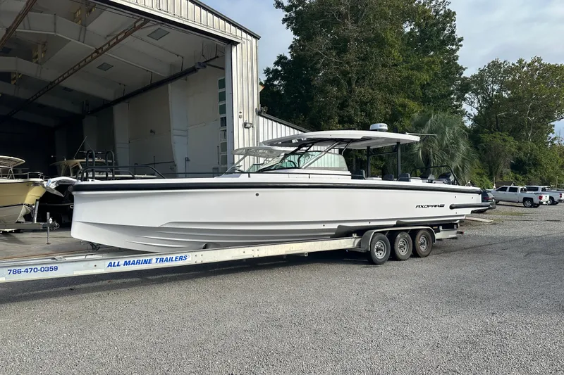 Slide: The Image of 2022 Axopar 37 Sun Top boat cruising on a calm river with lush greenery background. - 5