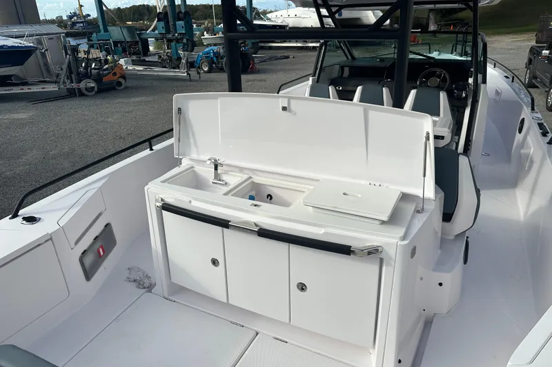 Slide: The Image of 2022 Axopar 37 Sun Top boat with open storage compartment and cushioned seating. - 9