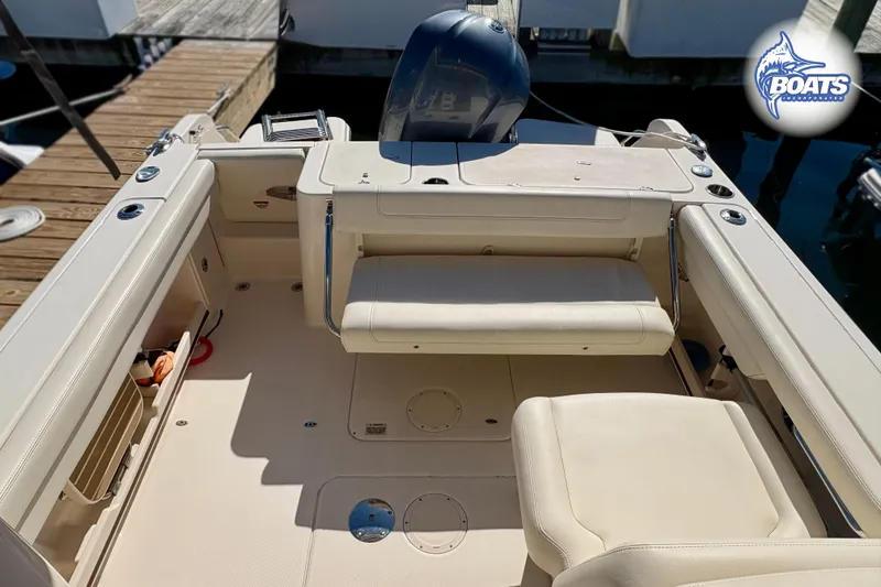 Slide: The Image of 2021 Grady-White Freedom 235 boat interior with seating and engine, docked at marina. - 11