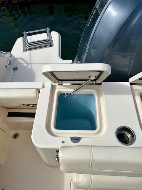 Slide: The Image of 2021 Grady-White Freedom 235 boat with open storage compartment and cup holder. - 13