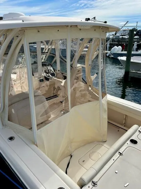 Slide: The Image of 2021 Grady-White Freedom 235 boat with enclosed cockpit, docked at marina. - 9