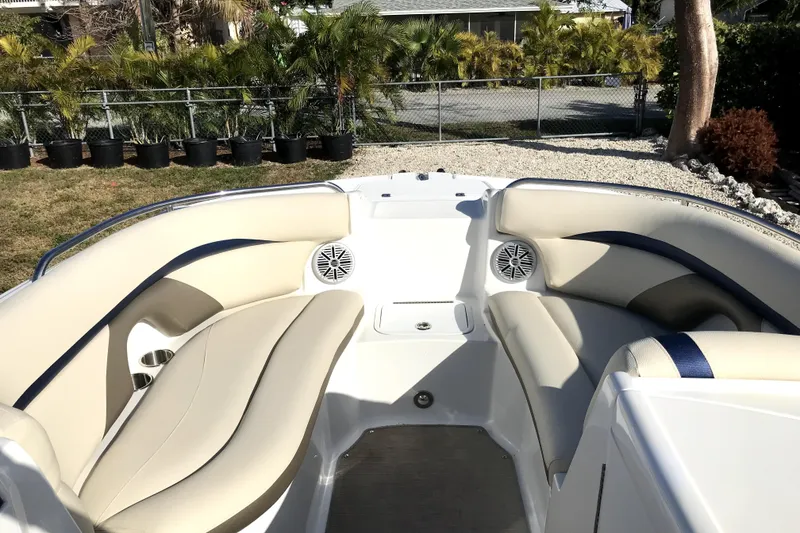 Slide: The Image of 2017 Hurricane SunDeck 2200 OB boat interior with beige seating and speakers. - 4