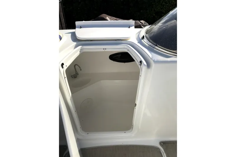 Slide: The Image of 2017 Hurricane SunDeck 2200 OB boat interior with open compartment and faucet. - 7