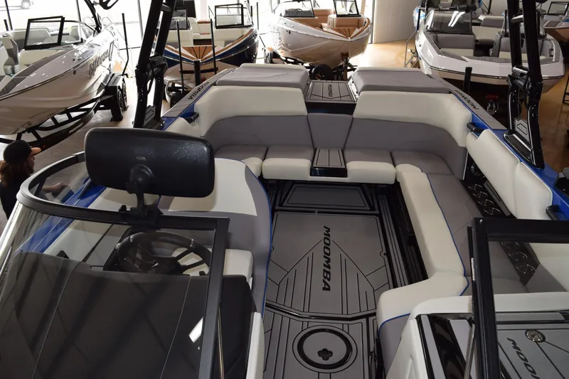 Slide: The Image of 2025 Moomba Max boat interior with spacious seating and modern design in showroom. - 10